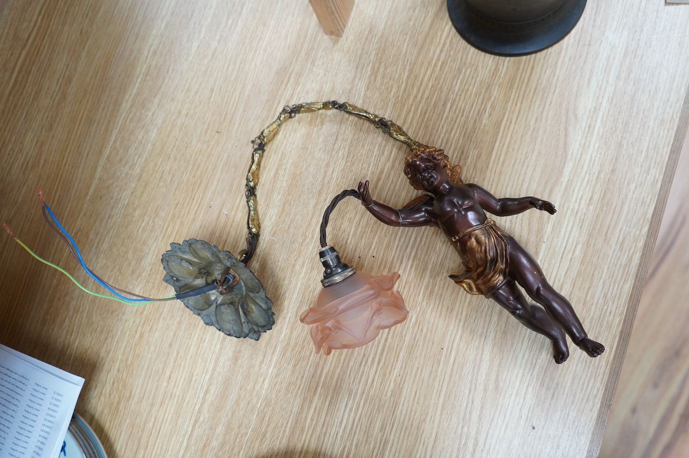 A French bronzed gilded cherub with pink petal shade, circa 1920’s, wired, cherub 23cm long. Condition - good.